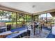 Covered porch with dining table, chairs, blue carpet, and view of the backyard garden at 7104 Castilla St, Port Charlotte, FL 33981