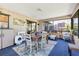 Enclosed porch featuring a dining set, blue carpet, and access to the backyard at 7104 Castilla St, Port Charlotte, FL 33981