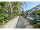 Beautiful backyard path with lush tropical landscaping and screened pool at 7453 Spinnaker Blvd, Englewood, FL 34224
