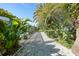 Backyard path leading to screened pool area with colorful tropical landscaping at 7453 Spinnaker Blvd, Englewood, FL 34224