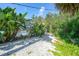 Backyard path leading to pool area with lush tropical landscaping at 7453 Spinnaker Blvd, Englewood, FL 34224