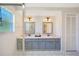 Bathroom featuring a dual sink vanity with two framed mirrors and tile flooring at 7453 Spinnaker Blvd, Englewood, FL 34224