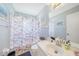 Well-lit bathroom with a decorative shower curtain, and a large vanity mirror at 7453 Spinnaker Blvd, Englewood, FL 34224