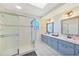 Bright bathroom featuring a large shower, dual sinks, and neutral tiling at 7453 Spinnaker Blvd, Englewood, FL 34224