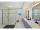 Bright bathroom featuring a large shower, dual sinks, and neutral tiling at 7453 Spinnaker Blvd, Englewood, FL 34224