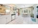 Eat-in kitchen features white cabinetry, tile floors, and adjacent dining area with ample natural light at 7453 Spinnaker Blvd, Englewood, FL 34224