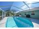 Refreshing screened-in pool offers a relaxing outdoor space with a grill and dining area at 7453 Spinnaker Blvd, Englewood, FL 34224
