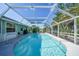 Private screened-in pool is surrounded by lush landscaping and ample deck space at 7453 Spinnaker Blvd, Englewood, FL 34224
