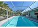 Sparkling screened-in pool surrounded by lush landscaping and comfortable lounge furniture at 7453 Spinnaker Blvd, Englewood, FL 34224