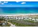 Aerial view of a beachfront community, showcasing the pristine white sand beach and sparkling blue ocean at 7500 Palm Island S Dr # 2111, Placida, FL 33946