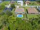 Aerial view of a backyard oasis featuring a pool surrounded by green foliage, in a residential area at 9151 Melody Cir, Port Charlotte, FL 33981
