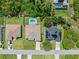 Aerial view of homes with well maintained lawns, pools, and long driveways on a residential street at 9151 Melody Cir, Port Charlotte, FL 33981