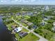 An aerial view of multiple homes with manicured lawns and lush landscaping in a waterfront community at 9151 Melody Cir, Port Charlotte, FL 33981