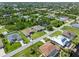 Wide aerial view of a neighborhood with houses surrounded by lush greenery and winding canals at 9151 Melody Cir, Port Charlotte, FL 33981