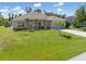Beautiful one-story home with stone pillars, blue door, and a lush green lawn at 9151 Melody Cir, Port Charlotte, FL 33981