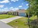 Charming one-story home featuring a blue garage door, stone accents, and a well-manicured lawn at 9151 Melody Cir, Port Charlotte, FL 33981