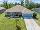 Well-maintained home featuring a manicured lawn, charming landscaping, and a two-car garage at 9151 Melody Cir, Port Charlotte, FL 33981