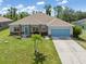 Beautiful single-Gathering home with stone accents, lush landscaping, and a well-manicured front yard at 9151 Melody Cir, Port Charlotte, FL 33981