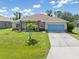 Inviting one-story home with a neatly kept lawn, a spacious driveway, and a charming entryway at 9151 Melody Cir, Port Charlotte, FL 33981