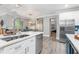 Open concept kitchen with stainless steel appliances, white cabinets, quartz countertops, and breakfast bar at 9151 Melody Cir, Port Charlotte, FL 33981