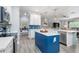 Bright kitchen with a blue island, quartz countertops, stainless steel appliances, and an open layout at 9151 Melody Cir, Port Charlotte, FL 33981