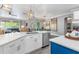 Modern kitchen with white cabinets, stainless steel appliances, quartz countertops and stylish lighting fixtures at 9151 Melody Cir, Port Charlotte, FL 33981