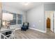 Comfortable sitting area with a blue chair, light gray walls, and wood-look flooring at 9151 Melody Cir, Port Charlotte, FL 33981