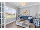 Cozy living room featuring a blue sofa, decorative pillows, and an outside view at 9151 Melody Cir, Port Charlotte, FL 33981