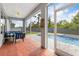 Inviting screened-in patio features wood-look flooring and views of the pool and fenced-in yard at 9151 Melody Cir, Port Charlotte, FL 33981