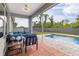 Relaxing screened-in patio with outdoor seating overlooking a sparkling pool and green backyard at 9151 Melody Cir, Port Charlotte, FL 33981
