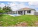 Backyard pool with covered patio and lush green grass, all enclosed by a privacy fence at 9151 Melody Cir, Port Charlotte, FL 33981