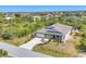 Stunning aerial view of home with landscaped front yard, paved driveway, and backyard patio at 9213 Spring Cir, Port Charlotte, FL 33981