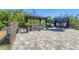 Well-manicured backyard featuring a hot tub under a pergola with brick pavers and privacy fence at 9213 Spring Cir, Port Charlotte, FL 33981