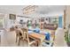 Open-concept dining area with a wooden table, pendant lighting, and views into the living room and kitchen at 9213 Spring Cir, Port Charlotte, FL 33981