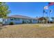 Exterior view of a blue building with gray trim, multiple windows, a paved walkway, and a flag pole at 9213 Spring Cir, Port Charlotte, FL 33981