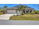 Beautiful single-Gathering home featuring stone accents, a two-car garage, and neat landscaping at 9213 Spring Cir, Port Charlotte, FL 33981
