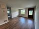 Spacious living room featuring hardwood floors, neutral walls, and a clear view of the front door at 38948 South Ave, Zephyrhills, FL 33542