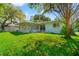 Spacious backyard with lush lawn and a charming blue single-story home with an enclosed patio at 8285 28Th N Ave, St Petersburg, FL 33710