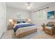 This staged bedroom is brightly lit with white walls and decorated with blue accents and wicker furniture at 8285 28Th N Ave, St Petersburg, FL 33710