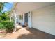 Charming covered front porch and garage, featuring a striking blue door, tiled surface, and lush plants at 8285 28Th N Ave, St Petersburg, FL 33710
