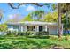 Charming single-story home featuring a well-manicured lawn, lush landscaping, and a welcoming blue front door at 8285 28Th N Ave, St Petersburg, FL 33710