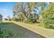 Expansive backyard featuring a lush lawn and mature trees offering shade and privacy at 14069 Wineberry Dr, Dade City, FL 33525