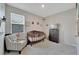 Cozy bedroom with neutral walls, soft carpet, and a charming crib and armchair at 14069 Wineberry Dr, Dade City, FL 33525