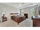 Spacious main bedroom with a tray ceiling, carpeted floor, and two side windows at 14069 Wineberry Dr, Dade City, FL 33525
