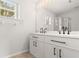 Bathroom featuring dual sinks, large mirror, and a walk-in shower at 3143 Grayton Dr, Spring Hill, FL 34609