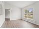 Bright bedroom with wood-look floors, a neutral paint color, and a large window for lots of light at 3143 Grayton Dr, Spring Hill, FL 34609