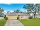 Well-maintained single-Gathering home featuring a lush front lawn and a paved driveway at 3143 Grayton Dr, Spring Hill, FL 34609
