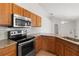 Kitchen featuring stainless steel appliances, granite countertops, and wooden cabinetry for a functional and stylish space at 3143 Grayton Dr, Spring Hill, FL 34609