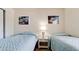Bedroom featuring twin beds, tropical wall art, and a matching bedside table at 4655 46Th Street Ct # 101, Bradenton, FL 34210