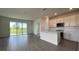 Modern kitchen with white cabinetry, a large island, and sliding glass doors leading to backyard at 9137 Gulf Haven Dr, Parrish, FL 34219